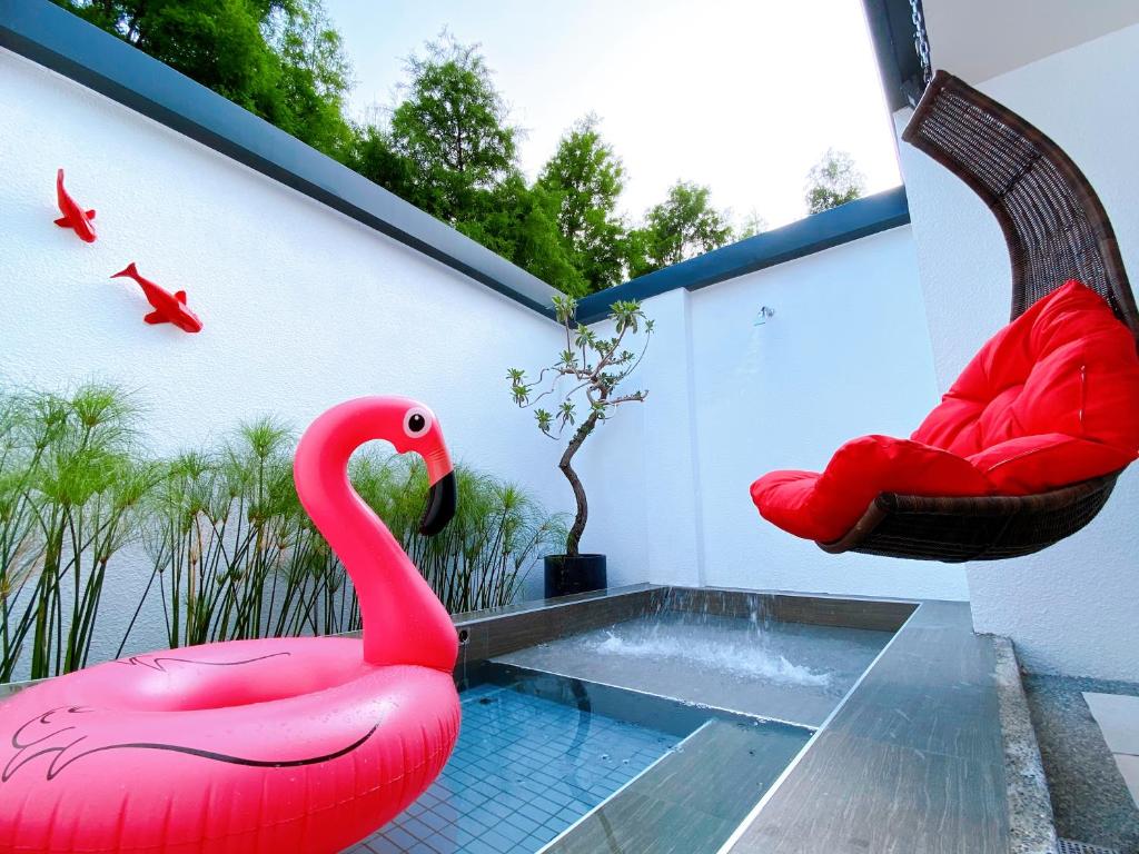 a large pink flamingo sitting next to a swimming pool at Shu Xin Motel in Nantou City