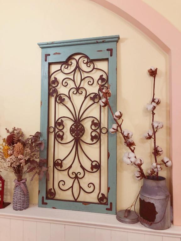 a mirror sitting on a shelf with flowers in vases at Fazhana Village B&amp;B in Hualien City