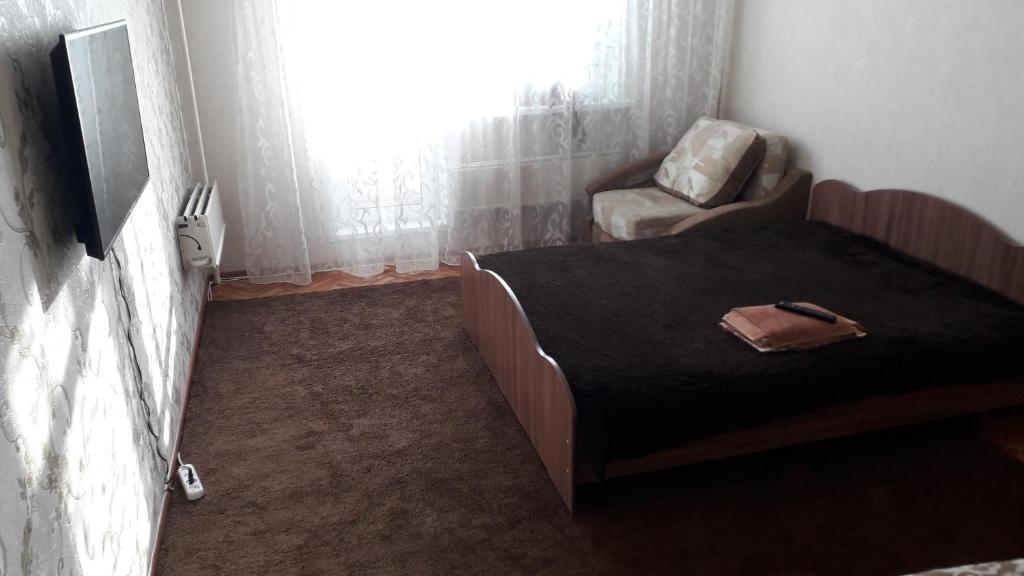 ニジネヴァルトフスクにあるApartment on Mira 15の小さなベッドルーム(ベッド1台、椅子付)