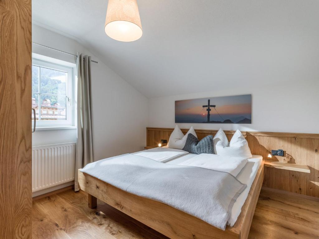 1 dormitorio con 1 cama grande con una cruz en la pared en Apartment Gossner, en Westendorf