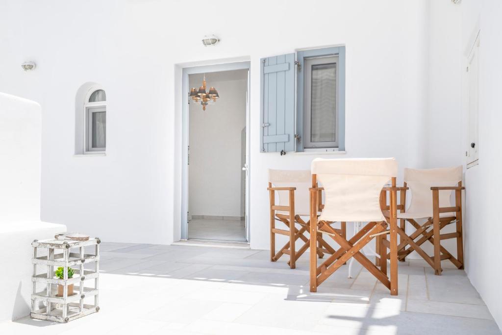 um quarto com paredes e cadeiras brancas e uma mesa em Arsis Houses, Small House em Antiparos