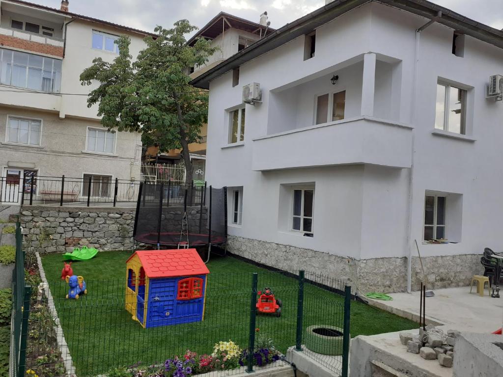 a playground in a yard next to a house at Къща за гости Калинови in Sandanski