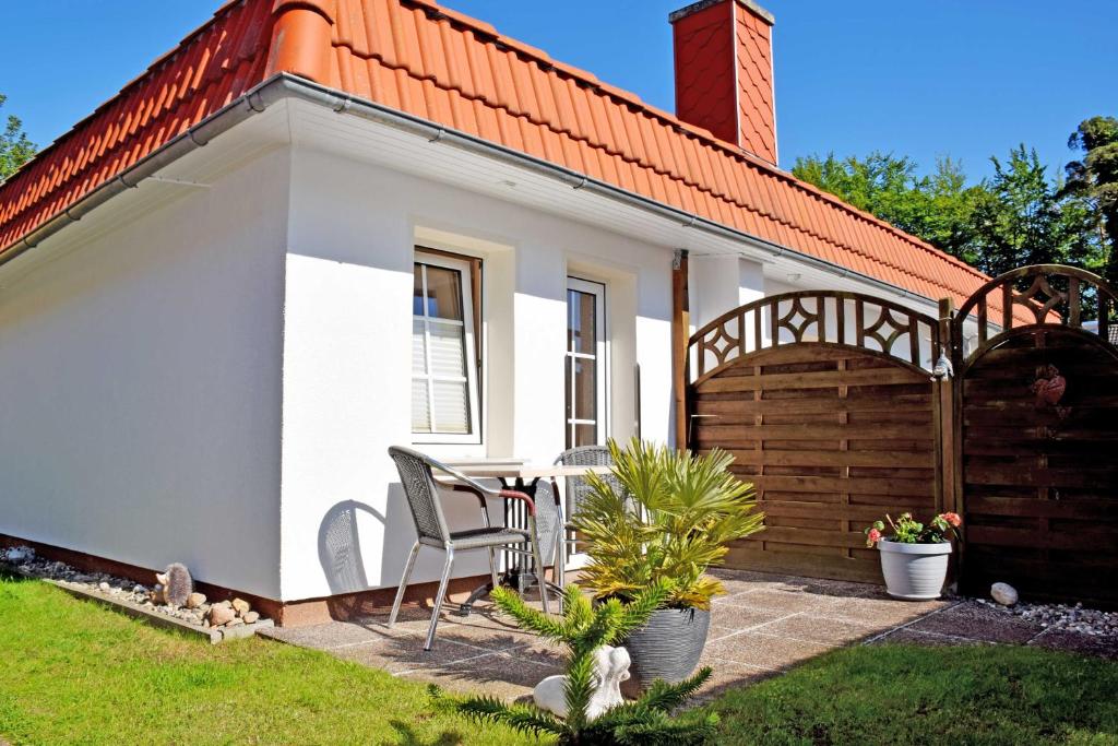 una casa blanca con una silla en el patio en Ferienwohnungen Familie Wilhelms, en Ostseebad Sellin
