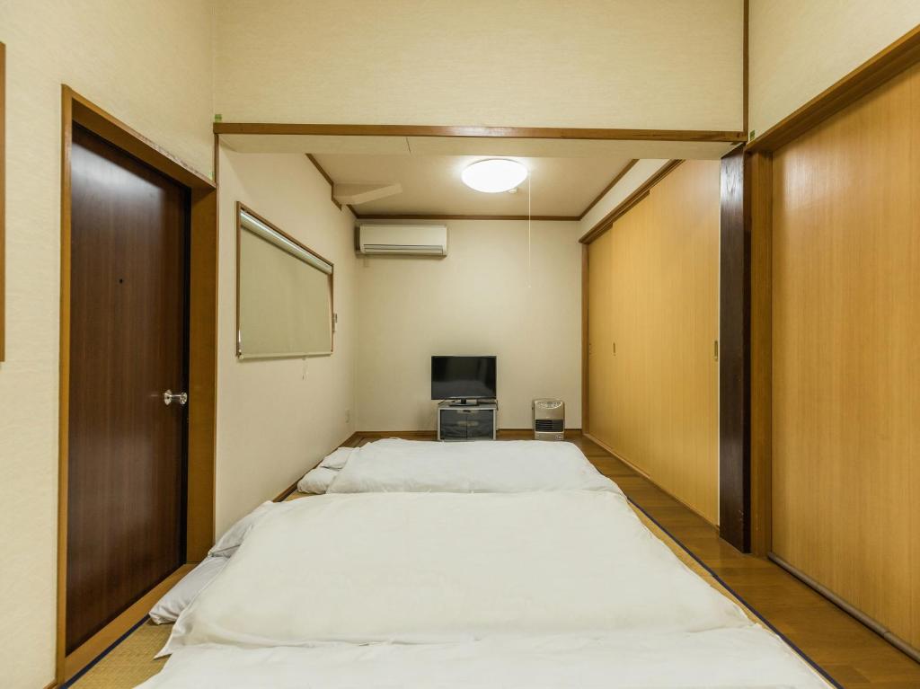 Postel nebo postele na pokoji v ubytování Tabist Miya Yokkaichi Suizawa