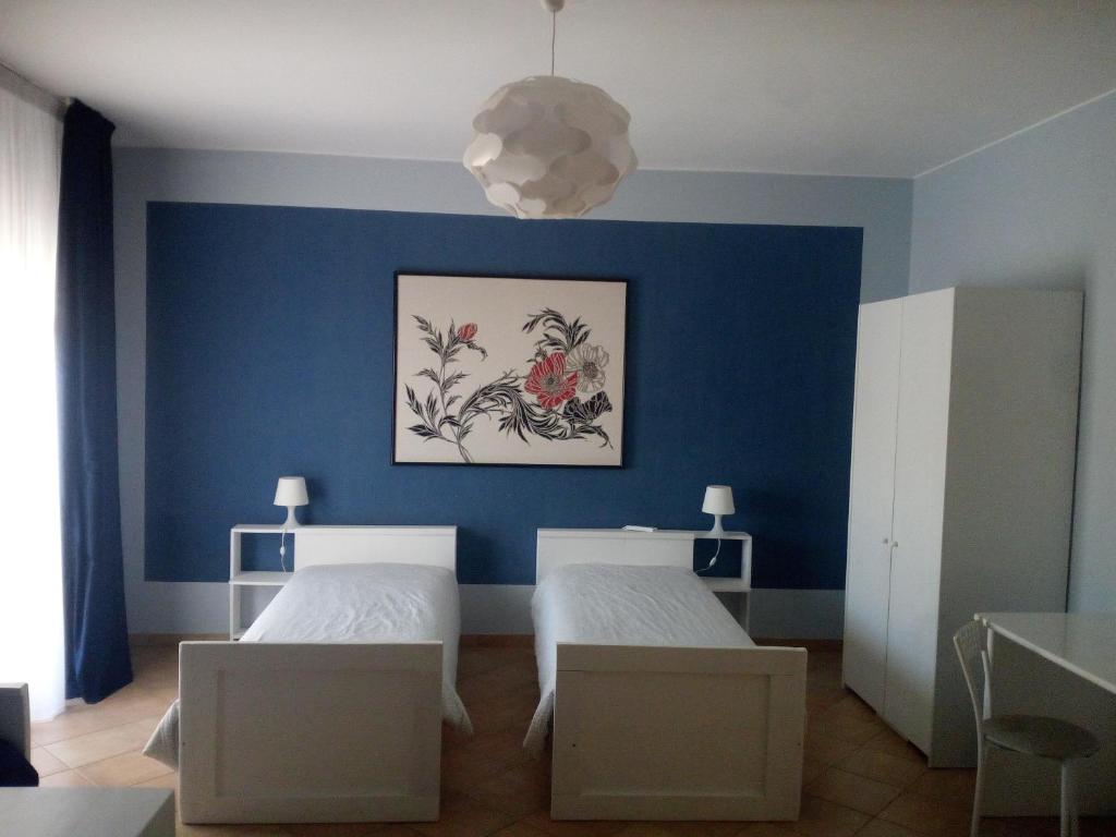 sypialnia z 2 łóżkami i niebieską ścianą w obiekcie The holiday house w mieście Santeramo in Colle
