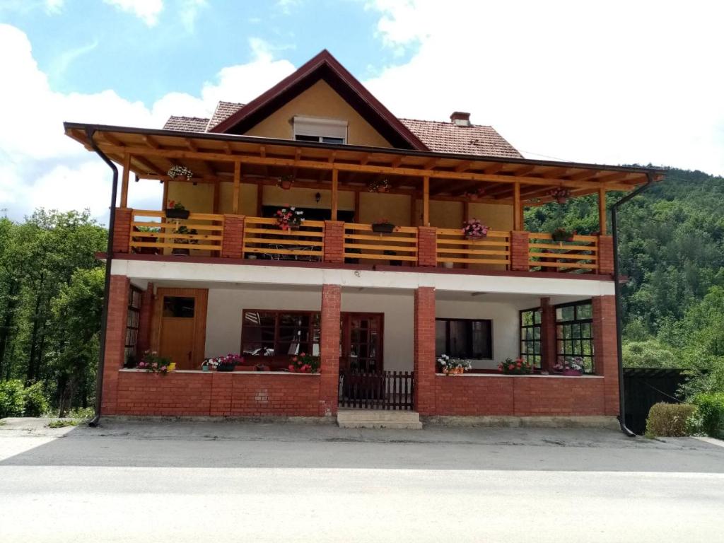 une maison avec un balcon sur une montagne dans l'établissement Apartman Dunja i Miloš, à Mokra Gora