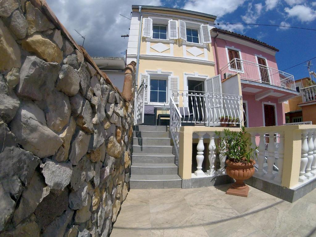 ein Haus mit einer Treppe und einer Steinmauer in der Unterkunft Holiday Home Sea Beach Dvorska 37 in Crikvenica