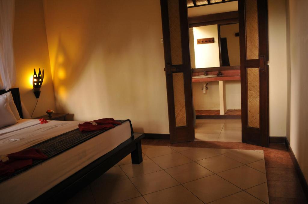 Postel nebo postele na pokoji v ubytování Tirta Sari Bungalow