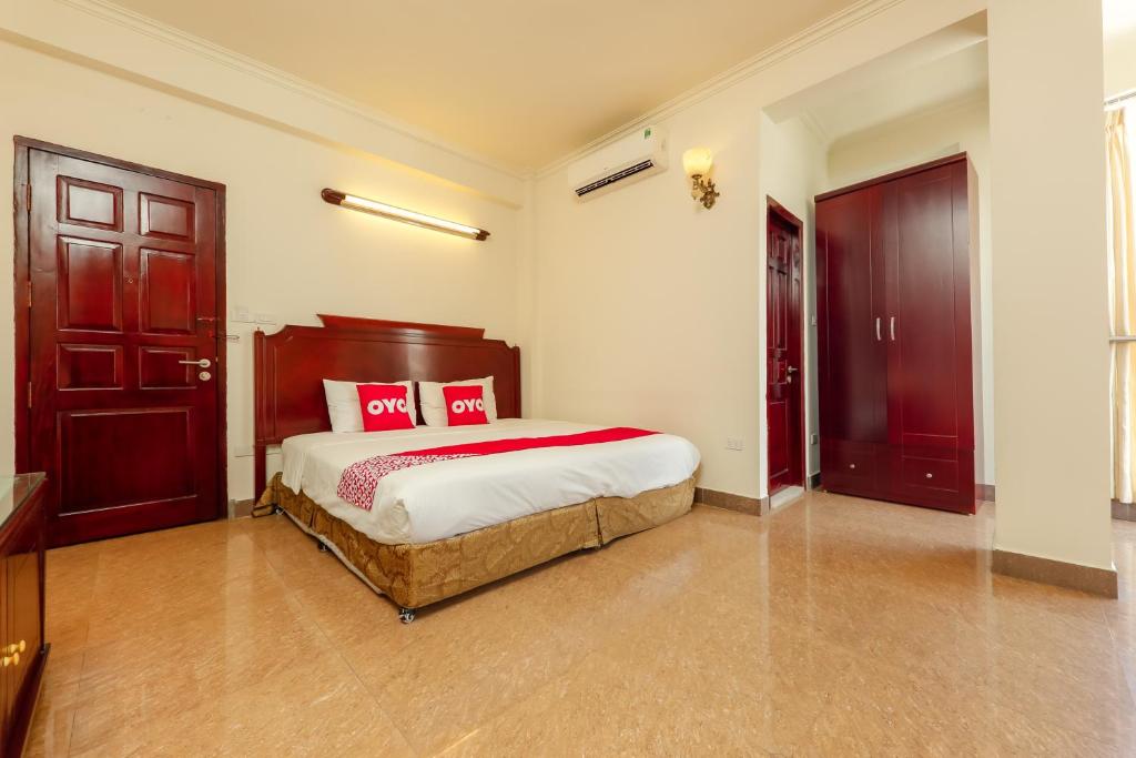 una camera da letto con un letto con cuscini rossi di Sunlight Hotel Hạ Long a Ha Long