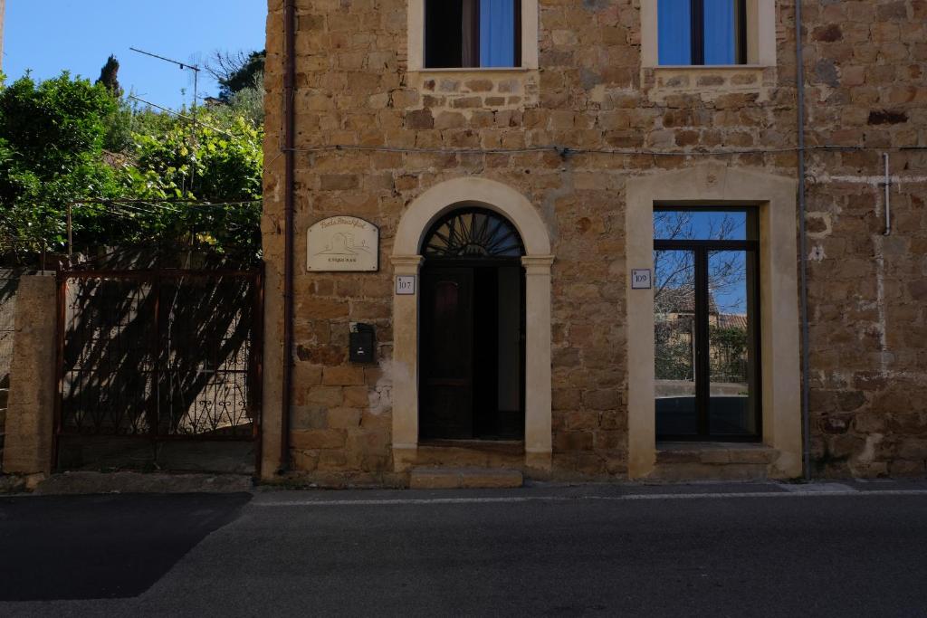 un edificio de ladrillo con puerta y ventana en Il Miglio in Più, en Castel di Tusa