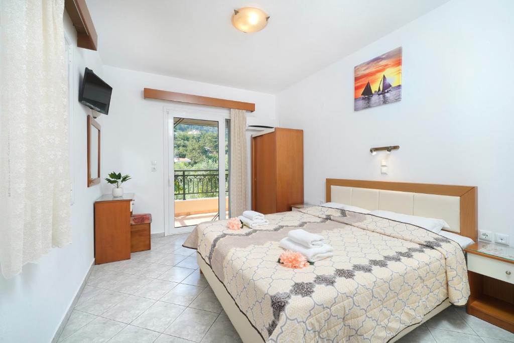 a bedroom with a large bed and a window at Apollonio in Chrysi Ammoudia