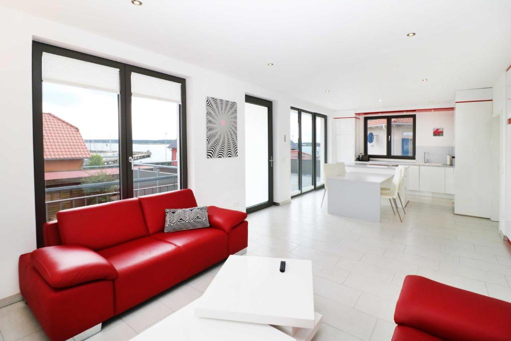 a living room with a red couch and a table at Ferienwohnung Leuchtfeuer 6 OG_ RO in Peenemünde