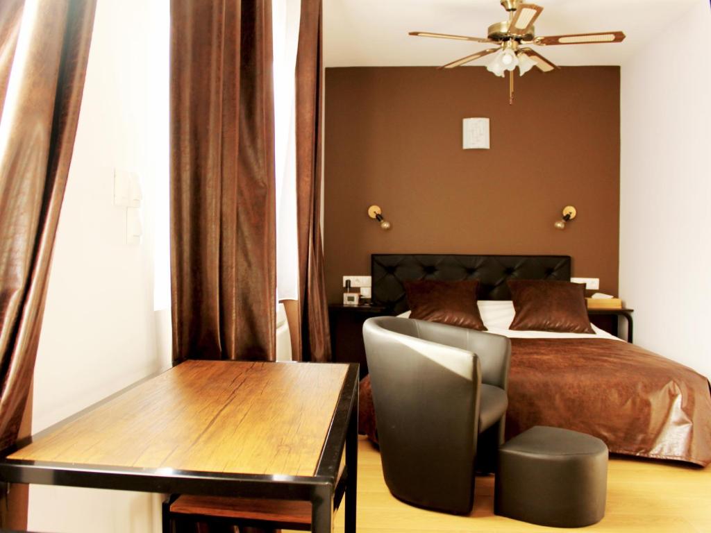 a bedroom with a bed and a desk and a table at Appart Hotel Relax Spa in Lens