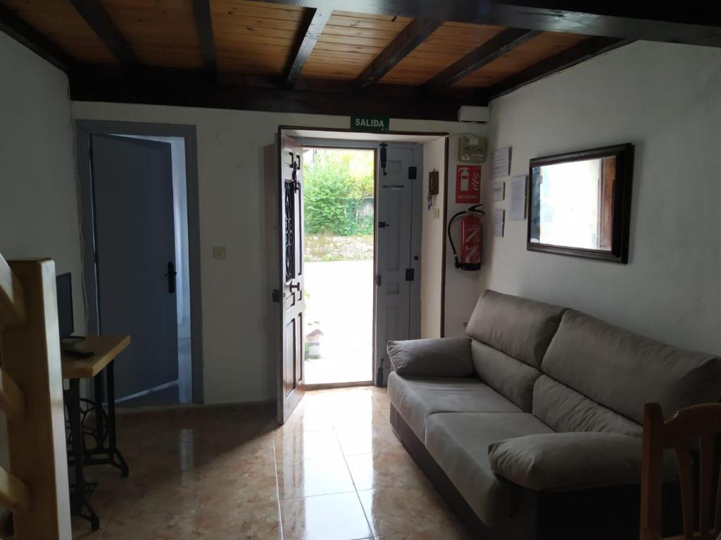 sala de estar con sofá y puerta abierta en Casa El Lavadero Prio, en Prío
