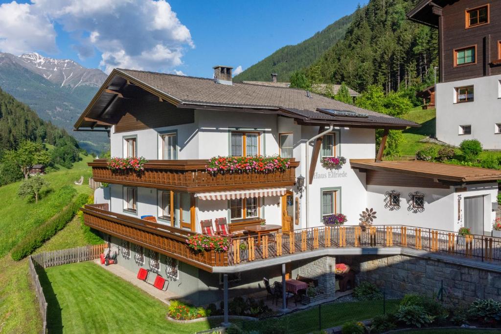 a house in the mountains with a balcony at Ferienwohnung Elfriede in Hopfgarten in Defereggen