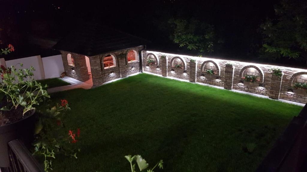 um jardim à noite com luzes na relva em Apartmani Kruna em Vrdnik