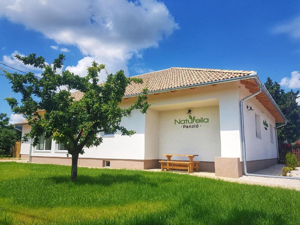 un edificio con un banco en un patio en Naturella Panzió en Villány