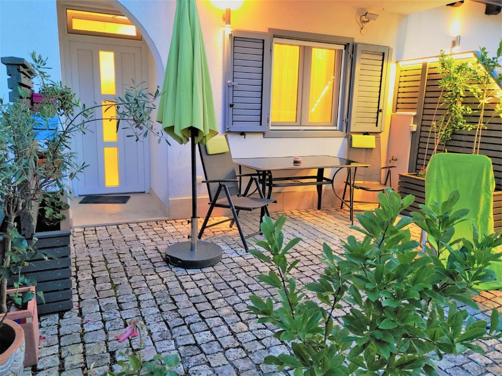 un patio con sombrilla, mesa y sillas en Apartments Sarc Rovinj, en Rovinj