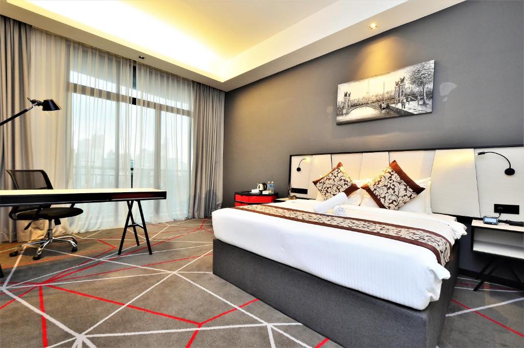 a hotel room with a large bed and a desk at Maison 101 Dang Wangi in Kuala Lumpur
