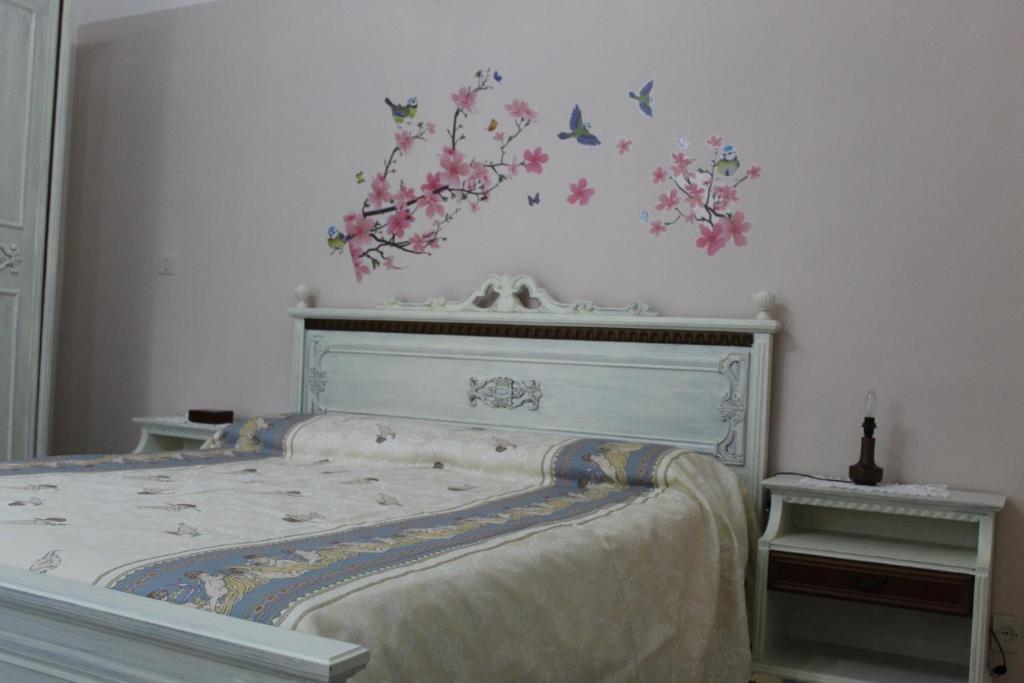 ein Schlafzimmer mit einem Bett mit Blumen und Vögeln an der Wand in der Unterkunft La casa sulla dolina in Campoli Appennino