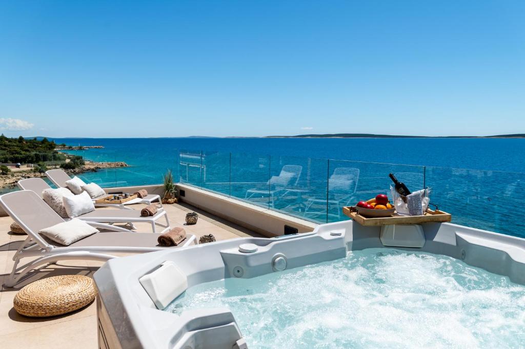 bañera de hidromasaje en el balcón con vistas al océano en Villa Natura luxury apartments en Mandre
