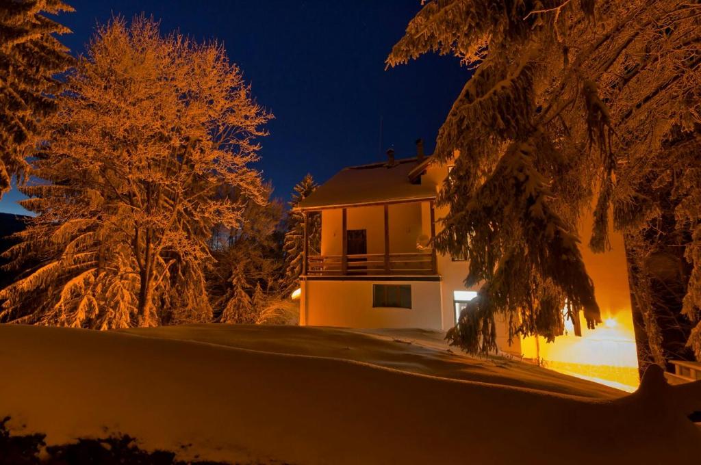 a house in the snow at night at Хижа Планинец - Тревненски балкан in Radevtsi