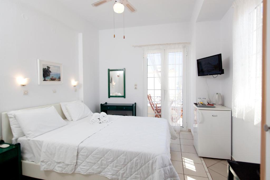 エラフォニソスにあるKontogoni Roomsの白いベッドルーム(白いベッド1台、テレビ付)
