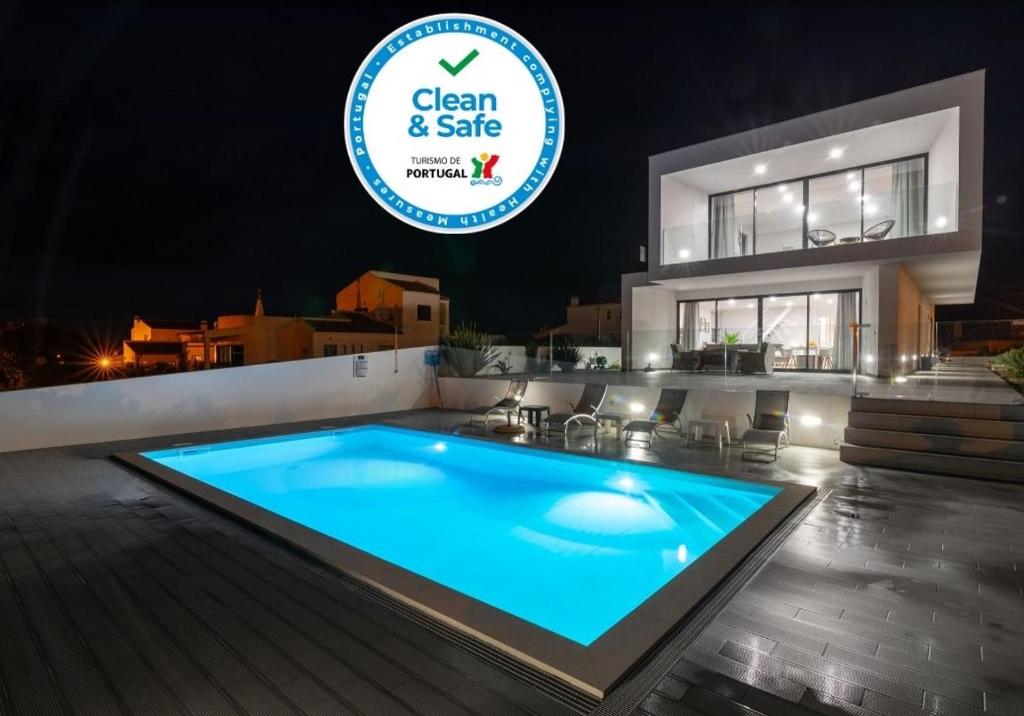 a swimming pool in front of a house at night at Biscuttela Vicentina in Praia da Arrifana