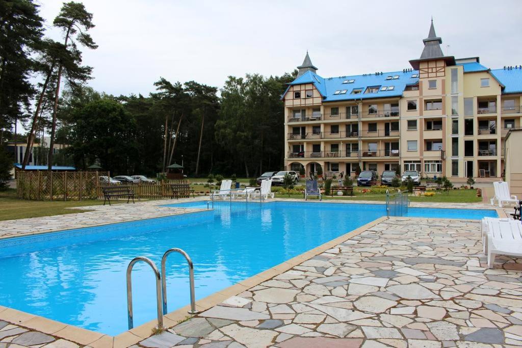 a hotel with a swimming pool in front of a building at jaren in Łukęcin