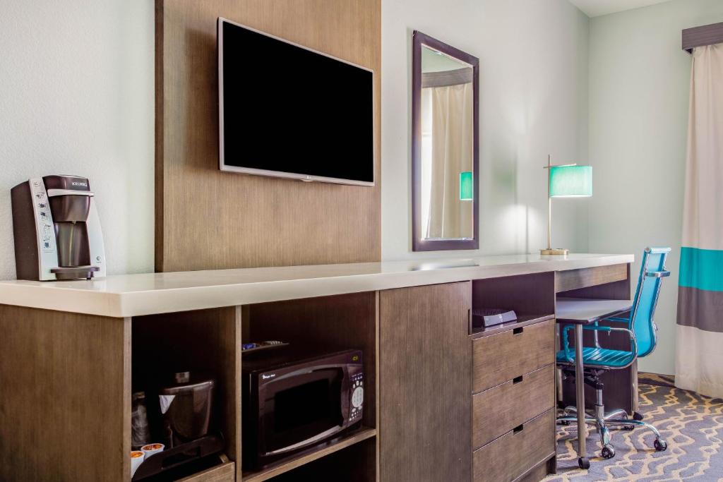 una camera d'albergo con TV a schermo piatto a parete di La Quinta Inn & Suites by Wyndham Northlake Ft. Worth a Northlake