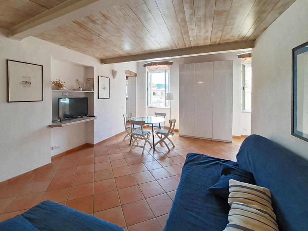 a living room with a blue couch and a table at Appartamento elegante a Marina di Campo in Campo nell'Elba