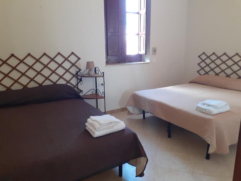 een kamer met twee bedden en handdoeken erop. bij Faraglioni house in Favignana