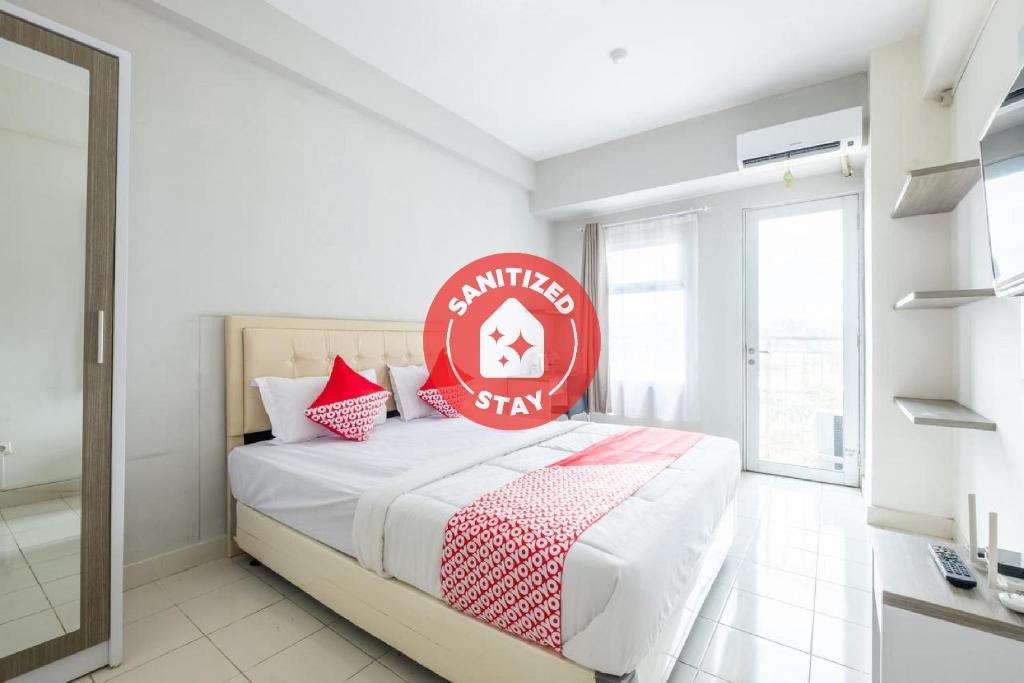 a bedroom with a bed with a red sign on it at OYO 1405 Easton Park Residence in Bandung