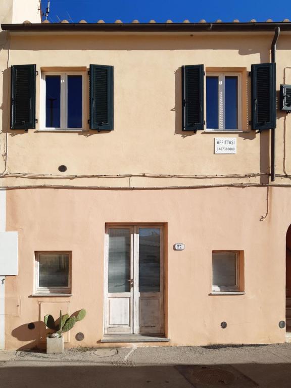 budynek z niebieskimi oknami i drzwiami w obiekcie Appartamento elegante a Marina di Campo w mieście Campo nell'Elba