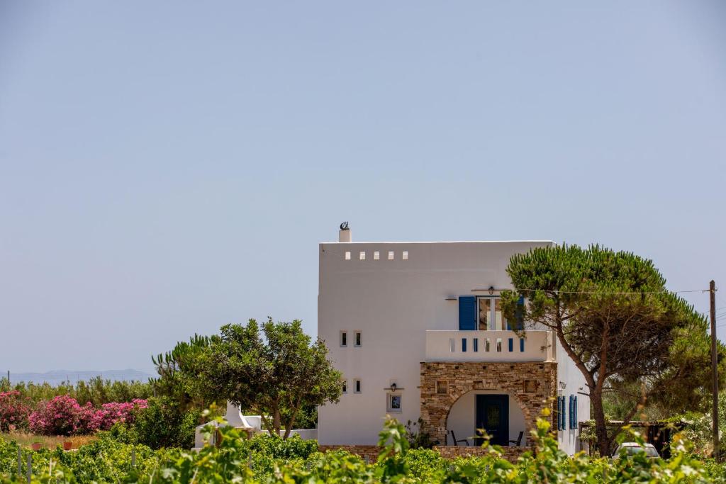 a white building with trees in the foreground at Oneiric Harmony in Mikri Vigla