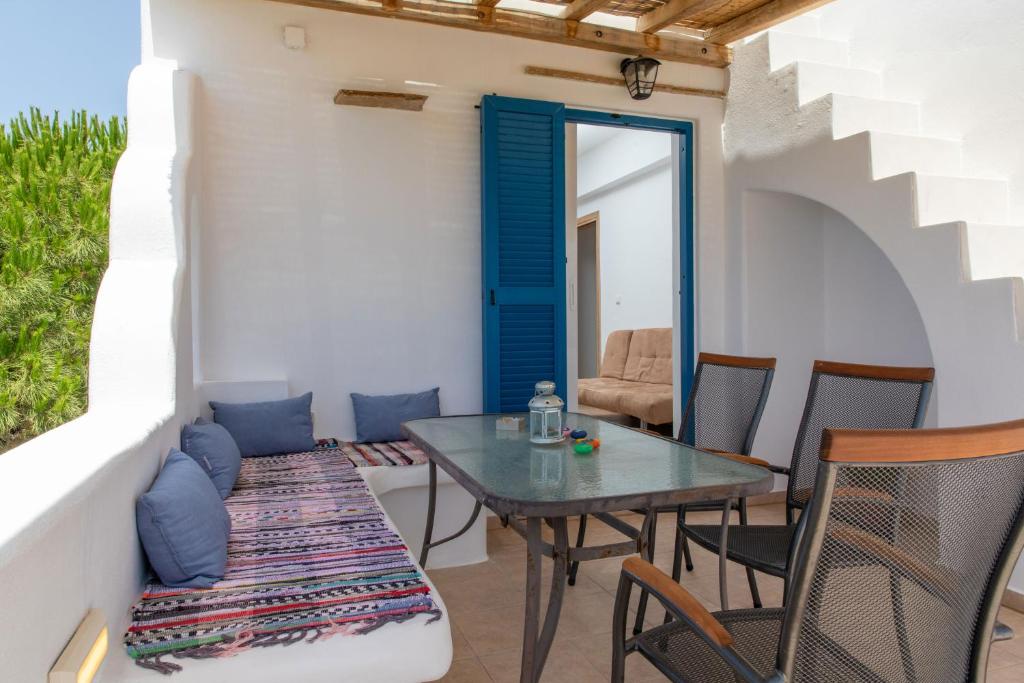 a patio with a table and chairs and a couch at Oneiric Harmony in Mikri Vigla