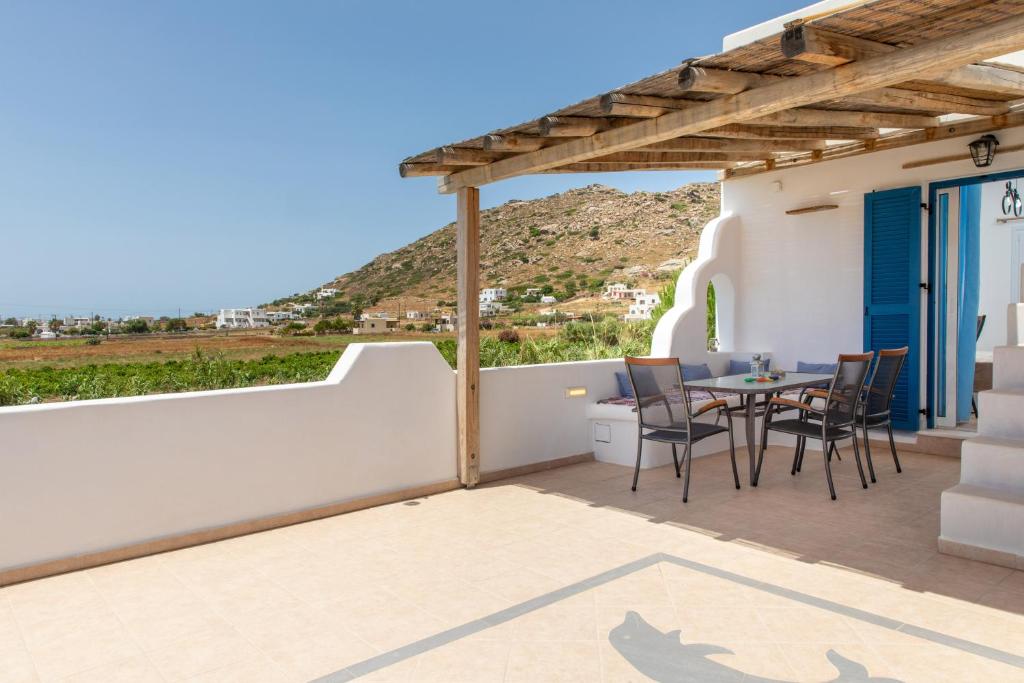 a patio with a table and chairs on a wall at Oneiric Harmony in Mikri Vigla