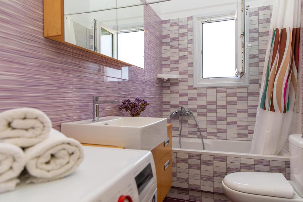 a bathroom with a sink and a toilet and a tub at Oneiric Harmony in Mikri Vigla