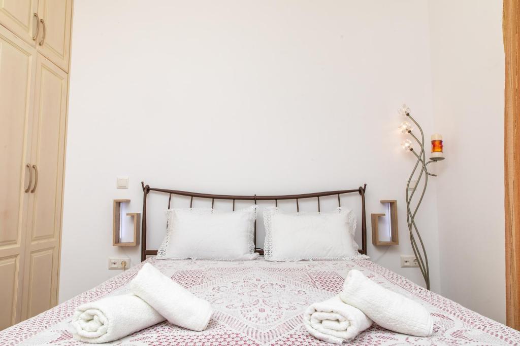 a white bedroom with a bed with two white pillows at Oneiric Harmony in Mikri Vigla