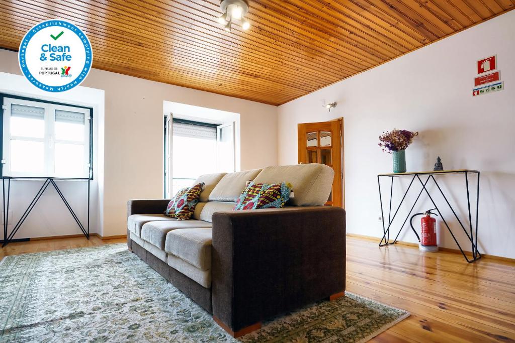 uma sala de estar com um sofá e um tecto de madeira em Apolónia Train Spot em Lisboa
