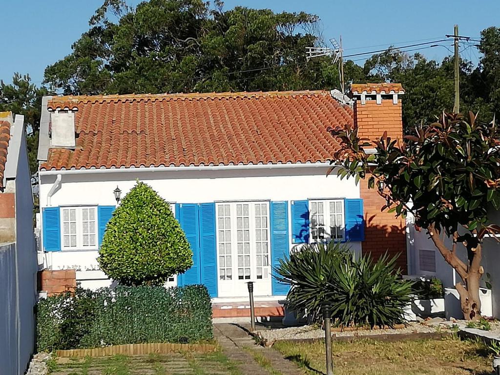 Casa de Praia في فيلا دو كوندي: بيت ابيض وزرق بسقف احمر