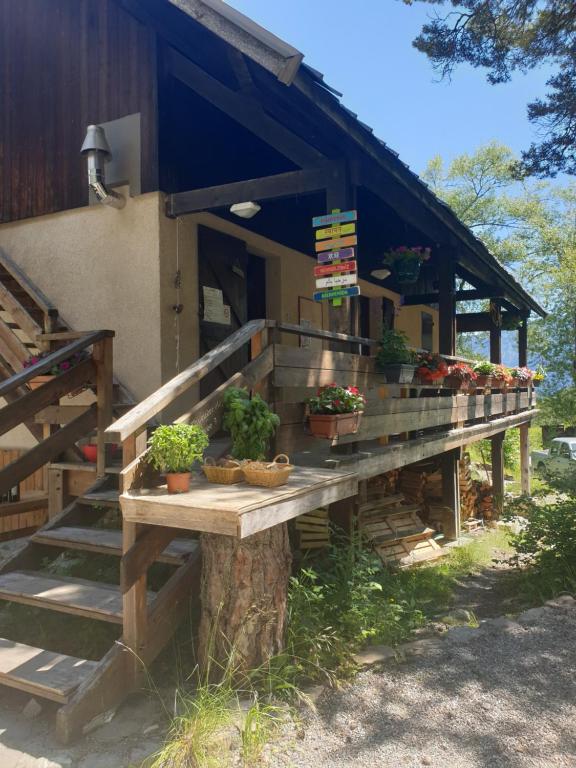 a porch of a house with potted plants on it at Les Pinées in Chateauroux-les-Alpes