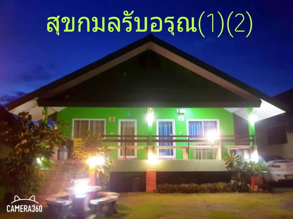 una casa verde con luces delante en สุขกมลรับอรุณแฝด2ห้อง en Chanthaburi