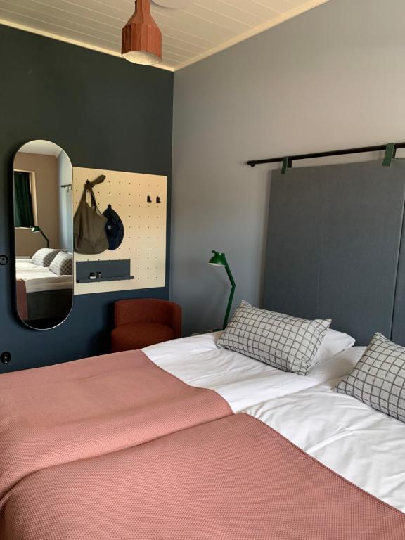 a bedroom with two beds and a mirror at Grundéns Hotell in Grundsund