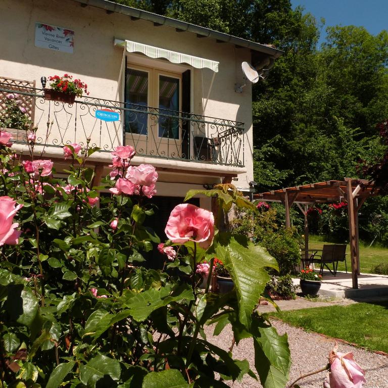 une maison avec des roses roses devant elle dans l'établissement La Garenne, à Exideuil