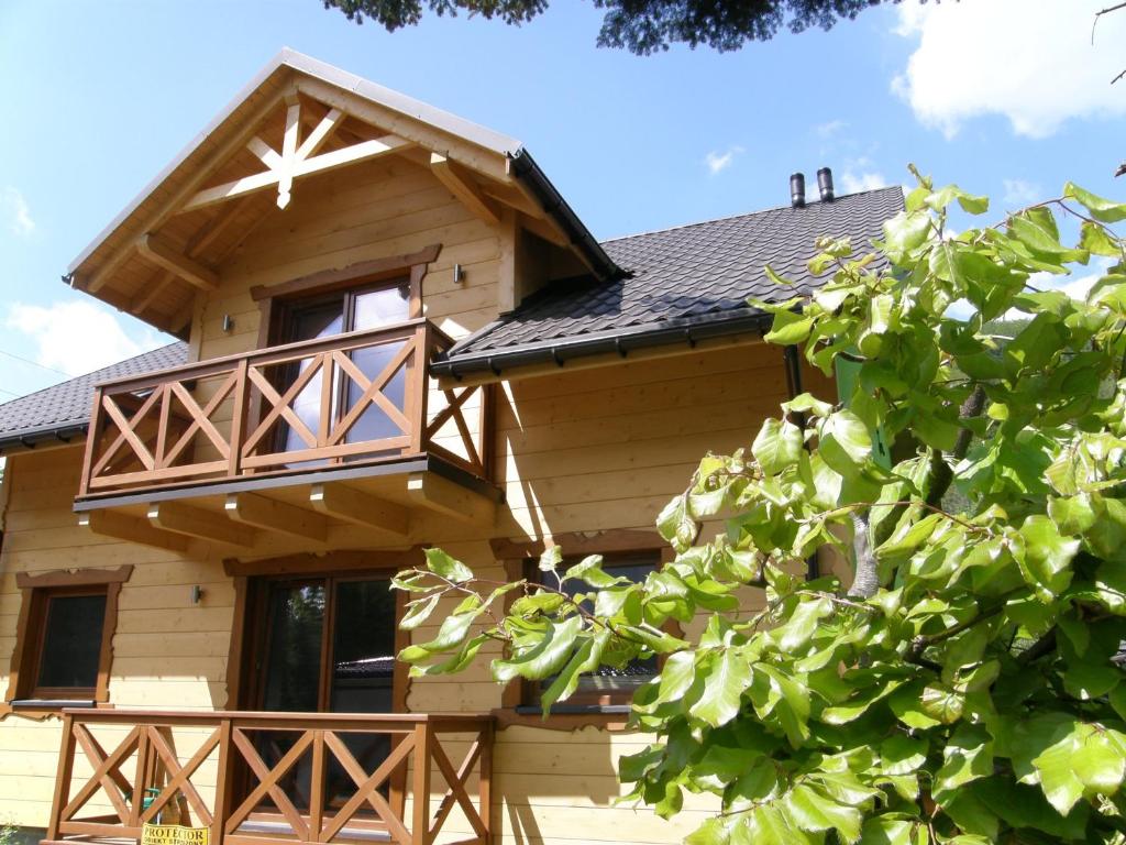 a log cabin with a porch and a balcony at Willa u Bartusia in Wisła