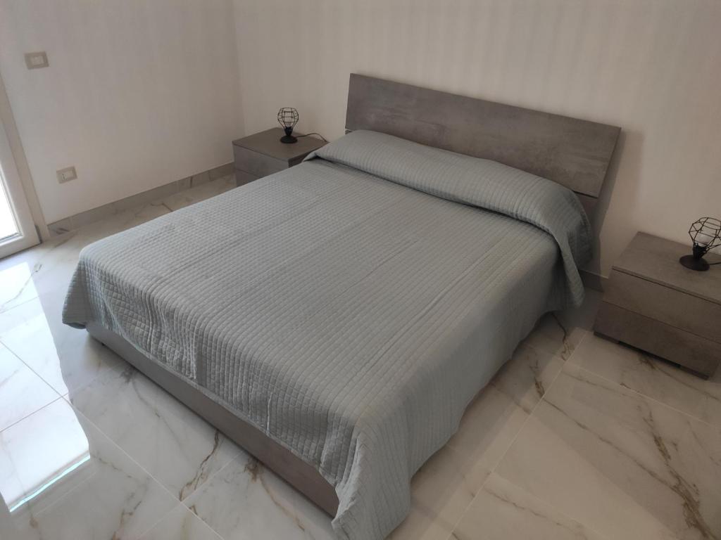 um quarto com uma cama grande e duas mesas de cabeceira em Casa Vacanze Vega em Porto Cesareo