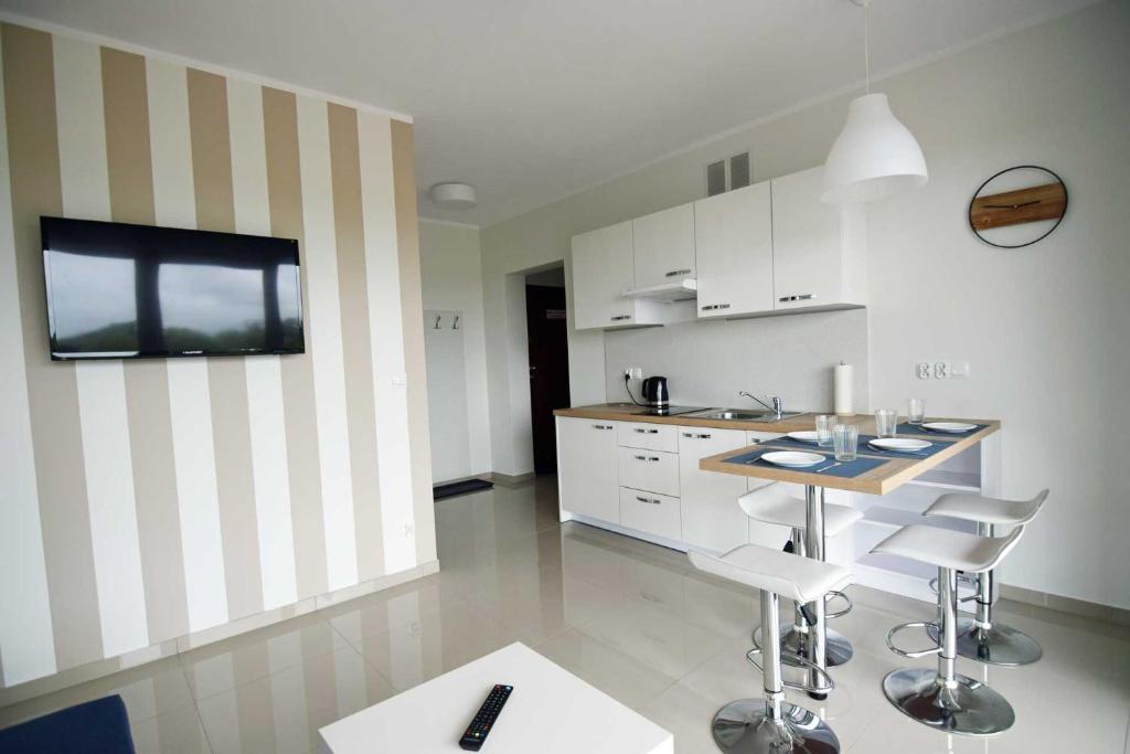 eine Küche mit einem Tisch und Stühlen im Zimmer in der Unterkunft Apartamenty Tropicana in Darłówko