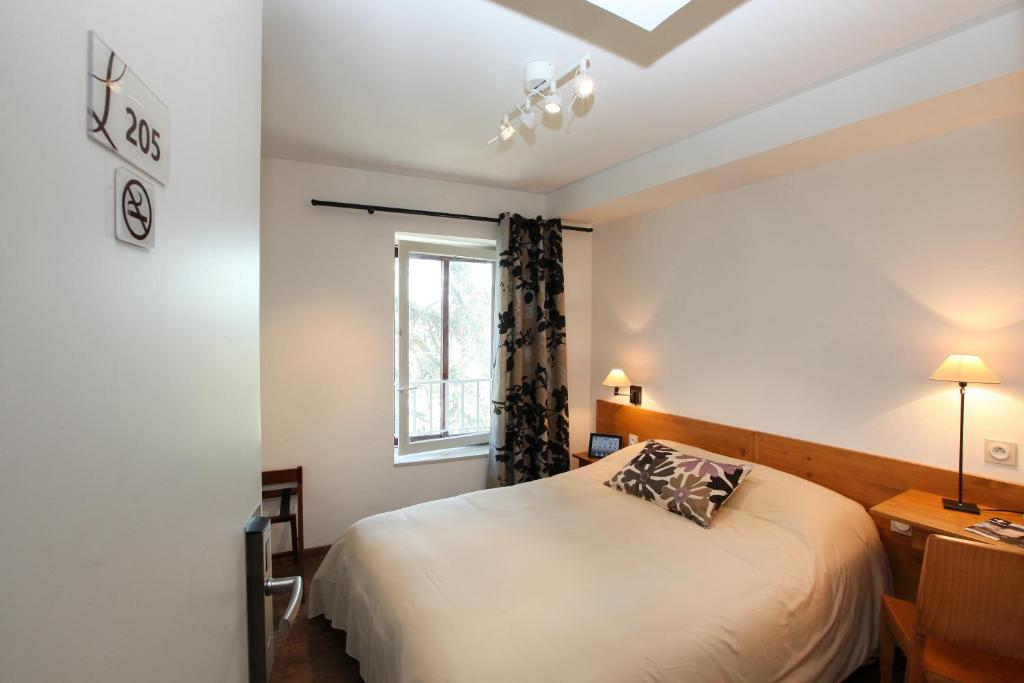 Postel nebo postele na pokoji v ubytování Logis Hotel Le Nouvel
