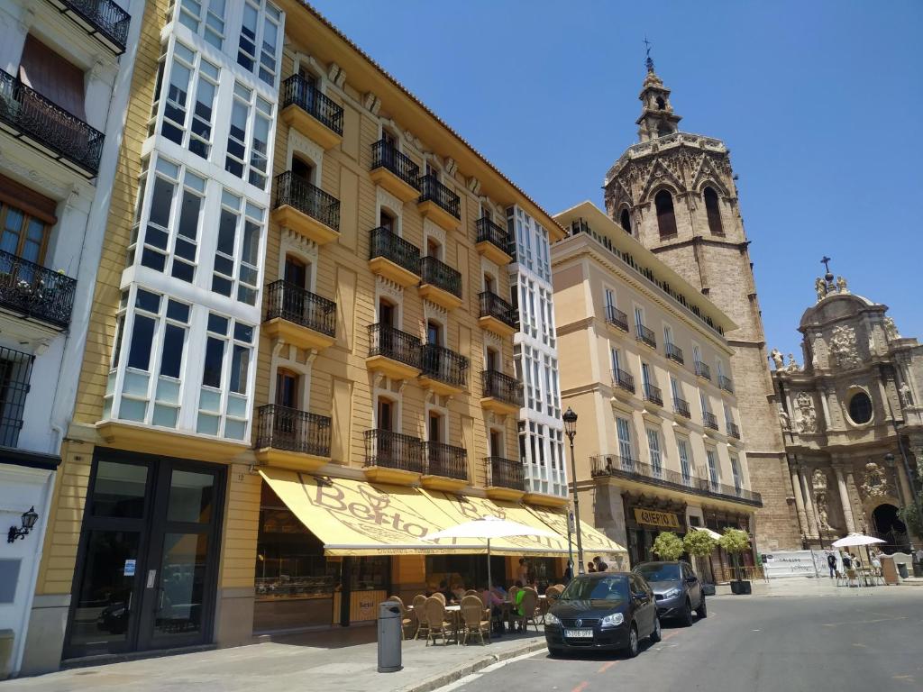 un edificio en una calle de la ciudad con una iglesia en Flats Friends Plaza de la Reina, en Valencia